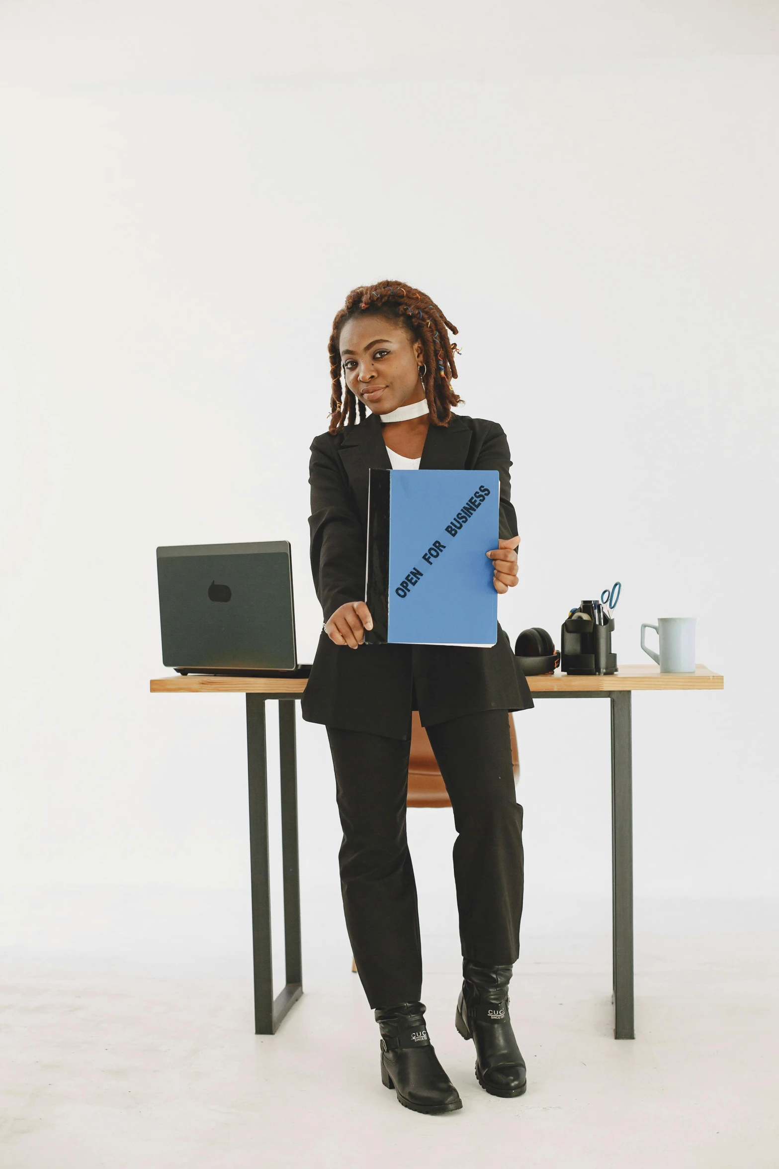 a woman sitting at a desk with a laptop, an album cover, trending on reddit, standing upright like people, subject action: holding sign, 2000s photo, business