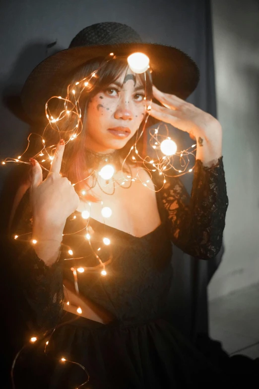 a woman in a witch costume holding a string of lights, a portrait, trending on pexels, asian woman, professional photo, glam photo, covered in circuitry