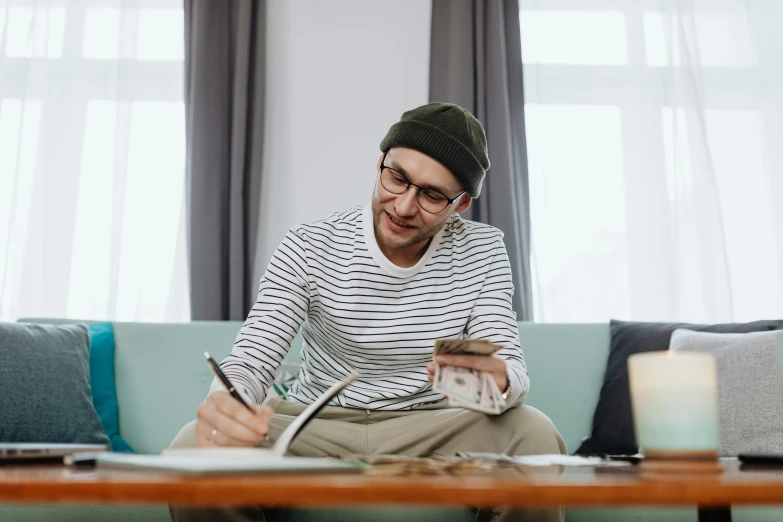 a man sitting on a couch using a cell phone, a drawing, pexels contest winner, cash on a sidetable, australian, striped, trying to study