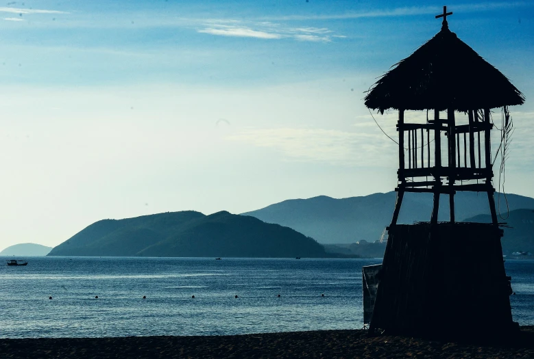 a small hut sitting on top of a beach next to the ocean, pexels contest winner, watch tower, profile image, lake kawaguchi, thumbnail