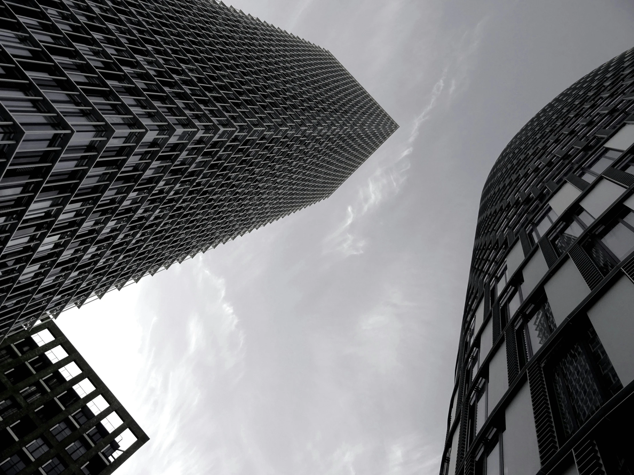 a couple of tall buildings next to each other, inspired by Zaha Hadid, pexels contest winner, zig zag, shades of grey, seen from outside, extremely hyperdetailed