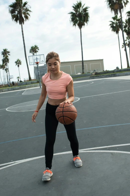 a woman standing on a basketball court holding a basketball, dribble, happening, taejune kim, oceanside, wearing a crop top, no watermark