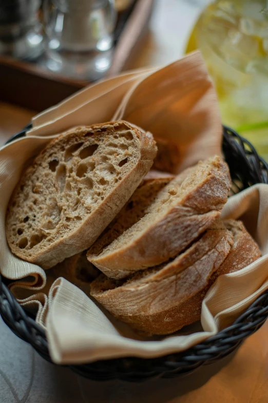 a basket of bread sitting on top of a table, upclose, daytime