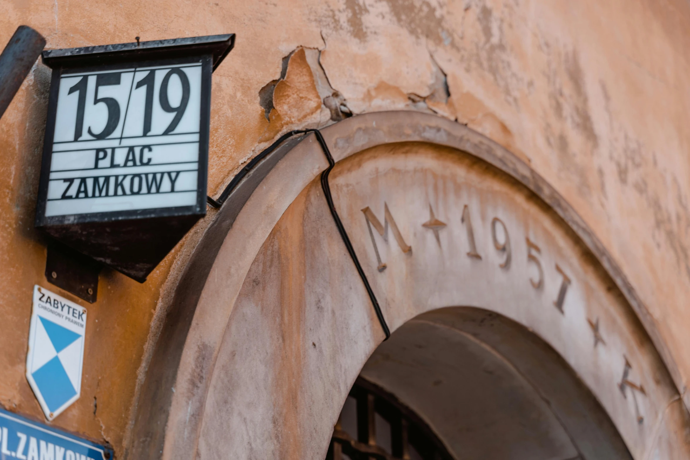 a street sign on the side of a building, by Adam Marczyński, pexels contest winner, neoclassicism, zdzislaw belsinki, arched doorway, historical event, profile image