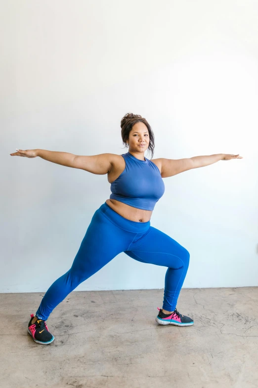 a woman in a blue top and leggings doing a lung lung lung lung lung lung lung lung lung lung lung lung lung lung lung lung, by Arabella Rankin, pexels contest winner, fit curvy physique, powerful stance, thicc build, stands in center with open arms