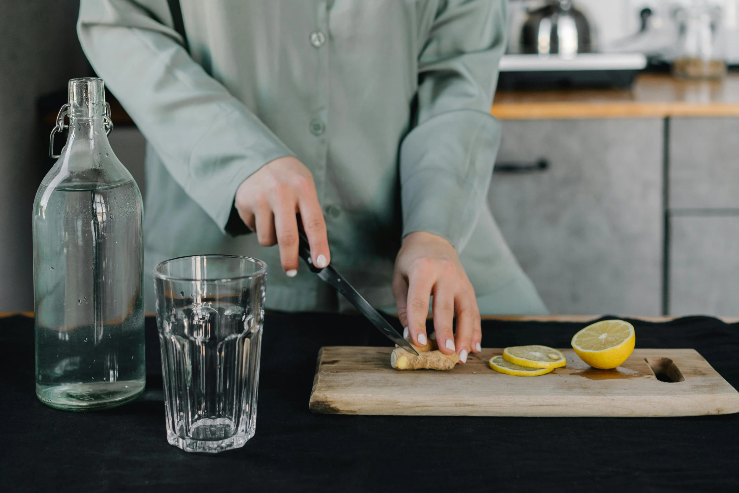 a person cutting a lemon on a cutting board, trending on pexels, renaissance, tall iced tea glass, plain background, chef table, set on night