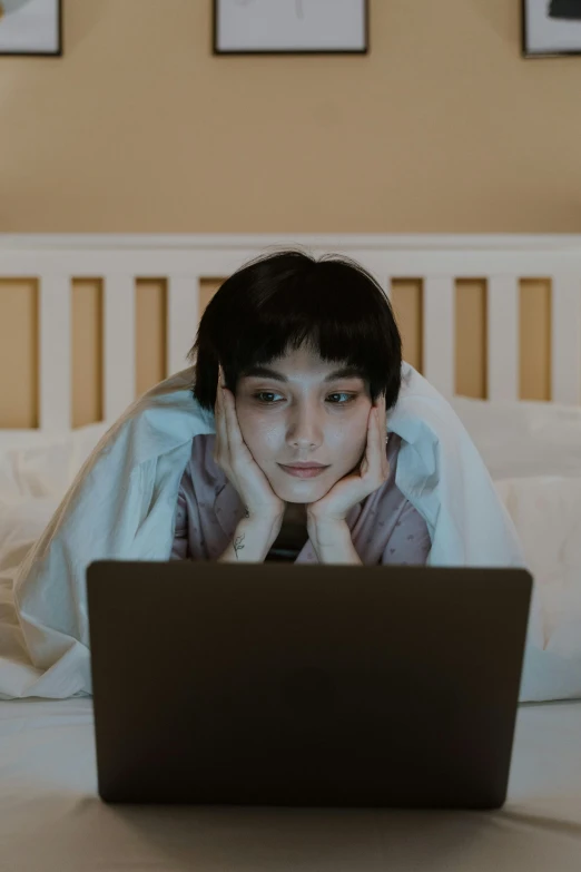 a person laying on a bed with a laptop, trending on pexels, happening, boy with neutral face, asian female, horror movie, looking across the shoulder