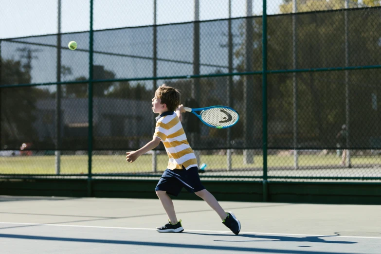 a young boy holding a tennis racquet on a tennis court, by Winona Nelson, pexels contest winner, mid air shot, panels, taken with canon 5d mk4, “ iron bark