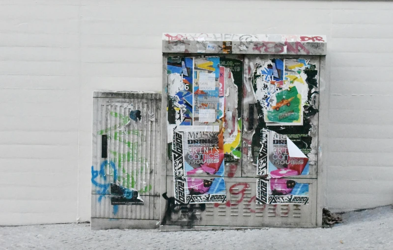 a refrigerator covered in graffiti next to a fire hydrant, a silk screen, inspired by Wolf Vostell, unsplash, massive decorated doors, newspaper, reykjavik, 2 0 5 6