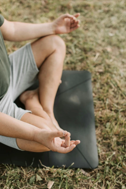 a man sitting on a yoga mat in the grass, a picture, unsplash, hands reaching for her, full frame image, trending photo, grey