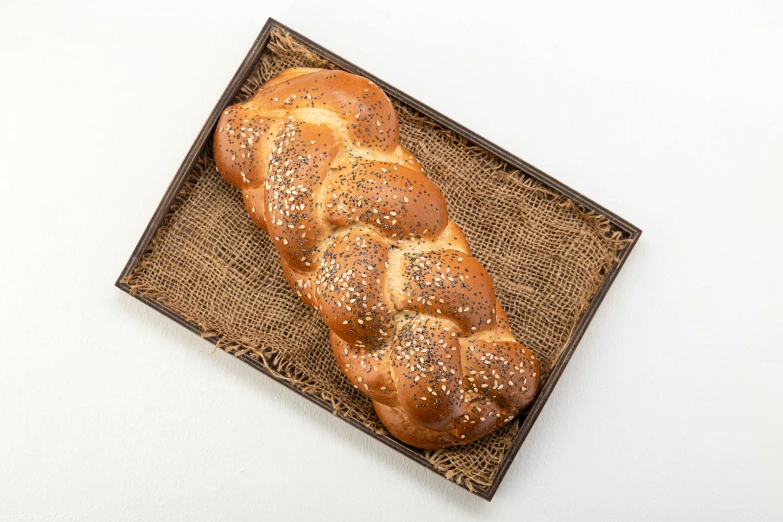 a loaf of bread sitting on top of a wooden tray, hebrew, gold speckles, twisted braid, detailed product image