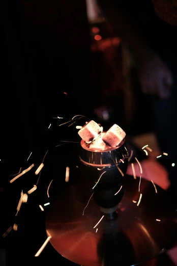 a close up of a person holding a bowl of marshmallows, by Ryan Pancoast, kinetic art, sparklers, lit. 'the cube', bartending, contain