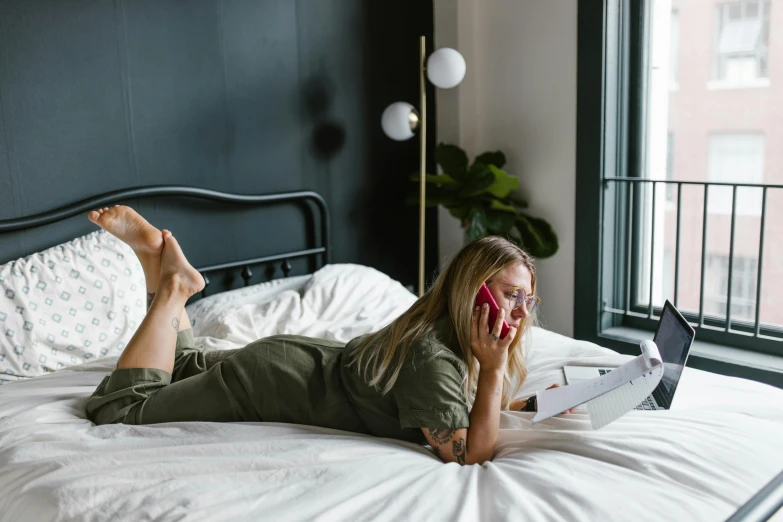 a woman laying on a bed using a laptop computer, by Julia Pishtar, trending on pexels, girl making a phone call, full body, reading a book, sydney sweeney