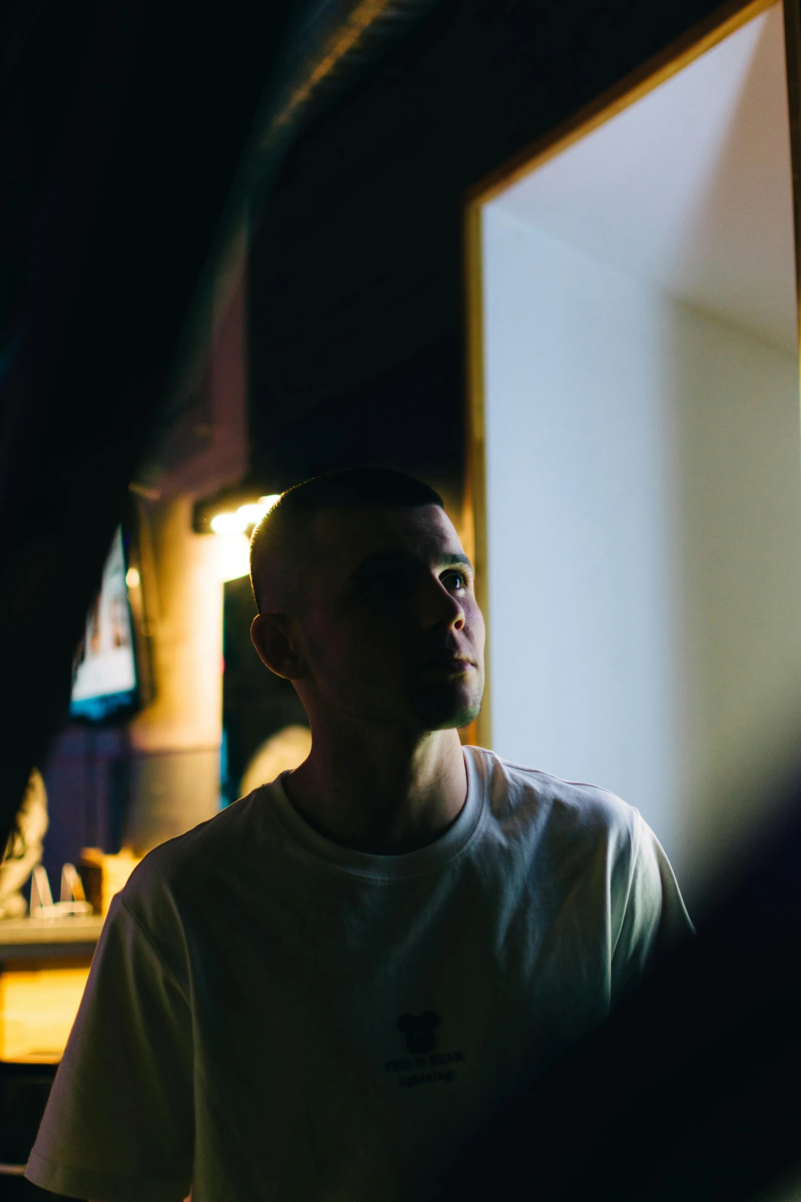 a man standing in front of a mirror in a room, by Nick Fudge, unsplash, buzz cut hair, yung lean, reflecting light in a nightclub, warm light