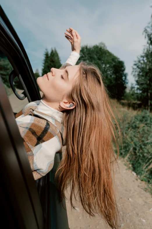 a woman leaning out the window of a car, trending on pexels, renaissance, brown flowing hair, ( 3 1, autumn wind, vibing to music