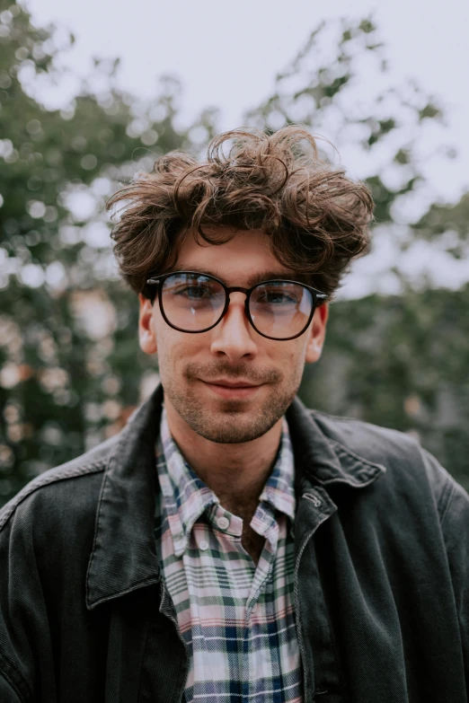 a close up of a person wearing glasses and a jacket, by Jacob Toorenvliet, messy curly hair, heavily upvoted, waist high, jay bauman