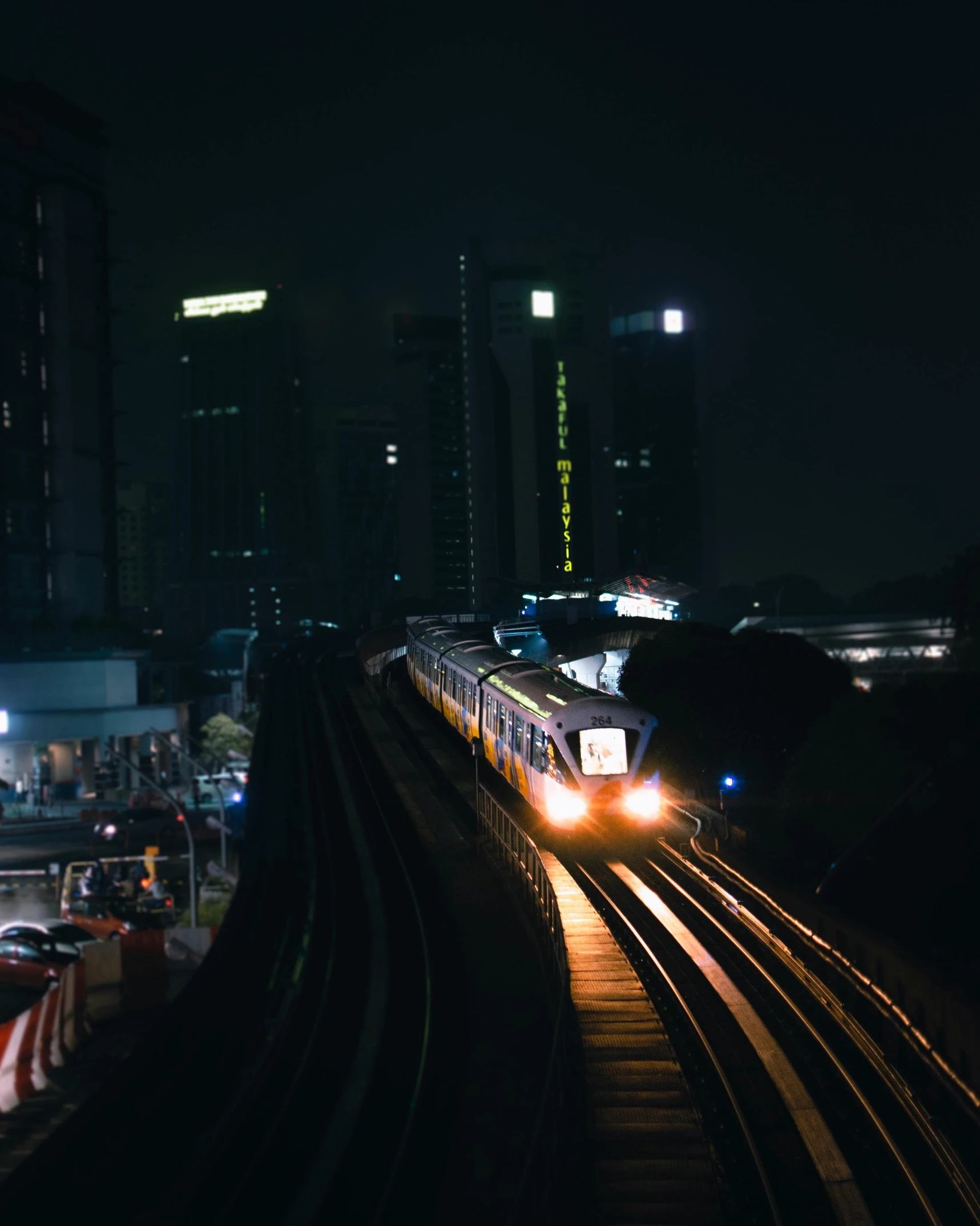 a train traveling through a city at night, set on singaporean aesthetic, jakarta, trending on vsco, journalism photo