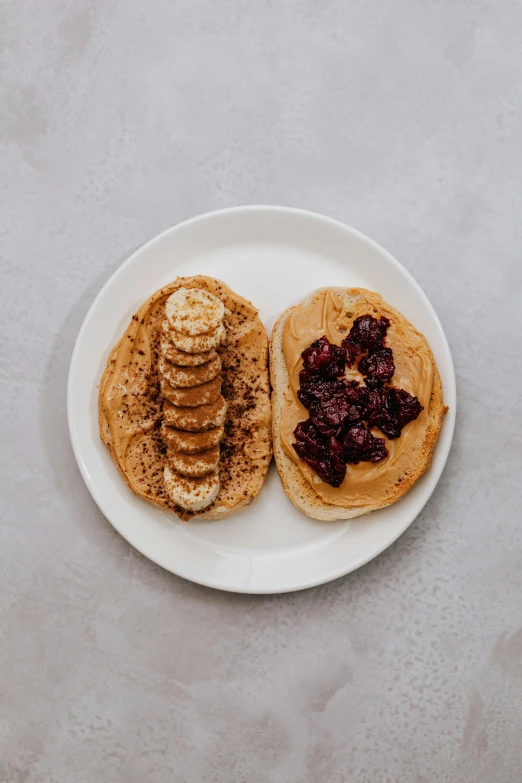 a white plate topped with peanut butter and jelly, inspired by Richmond Barthé, pexels contest winner, split near the left, bagels, banana, ivy's