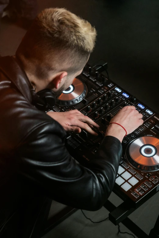 a man in a leather jacket using a dj controller, by artist, trending on unsplash, 15081959 21121991 01012000 4k, a blond, action sports, rectangle