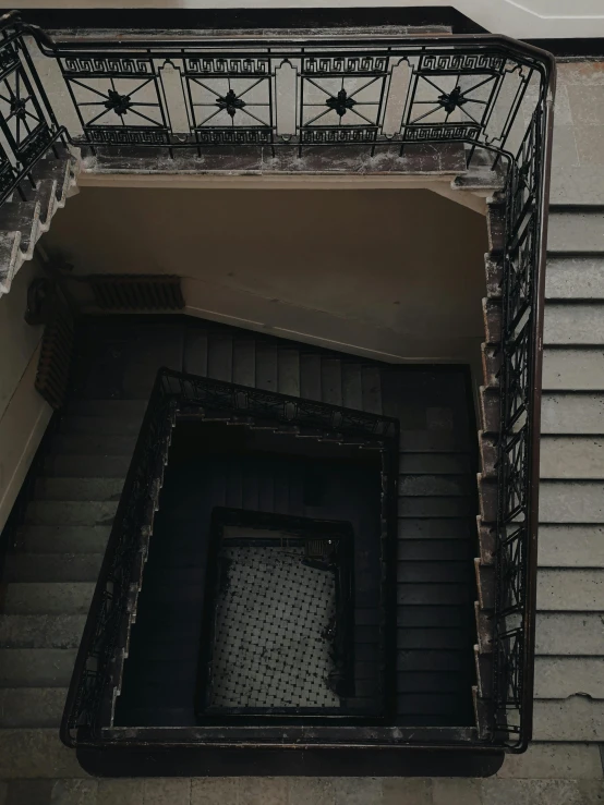 a clock that is on the side of a building, an album cover, inspired by Elsa Bleda, pexels contest winner, baroque, stairways, ignant, dark aesthetic, looking down at you