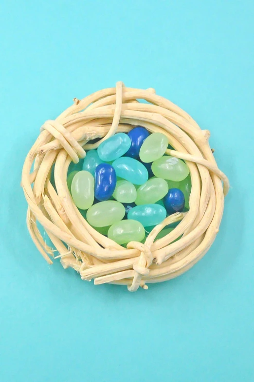 a bird nest filled with green and blue stones, candy pastel, video