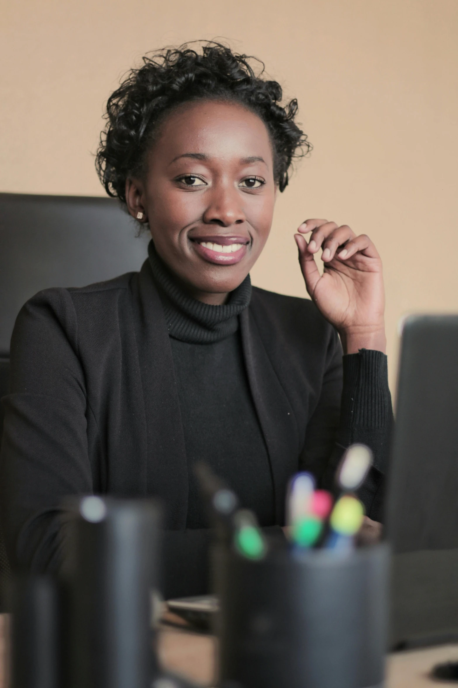 a woman sitting in front of a laptop computer, by Afewerk Tekle, professional corporate portrait, on a desk, keter class, professional profile picture