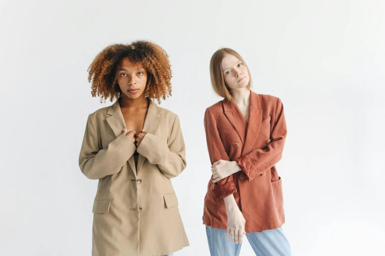 a couple of women standing next to each other, trending on pexels, renaissance, brown jacket, varying ethnicities, product introduction photo