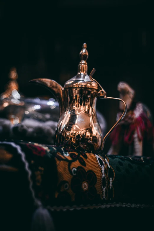 a silver tea pot sitting on top of a table, arabian night, in dark robes with gold accents, piping, top selection on unsplash