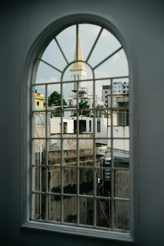 a view of a city through a window, lead - covered spire, bangladesh, cuban setting, looking in front