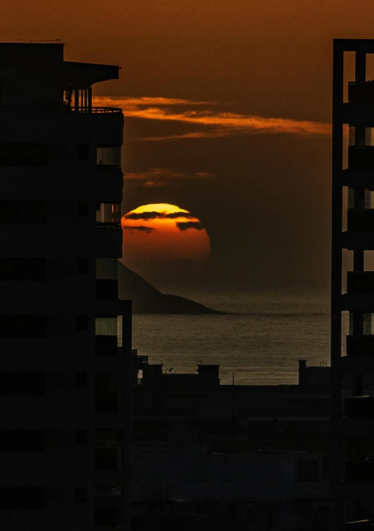 the sun is setting over the ocean from a high rise building, by Matt Stewart, slide show, puerto rico, ((sunset)), stacked image