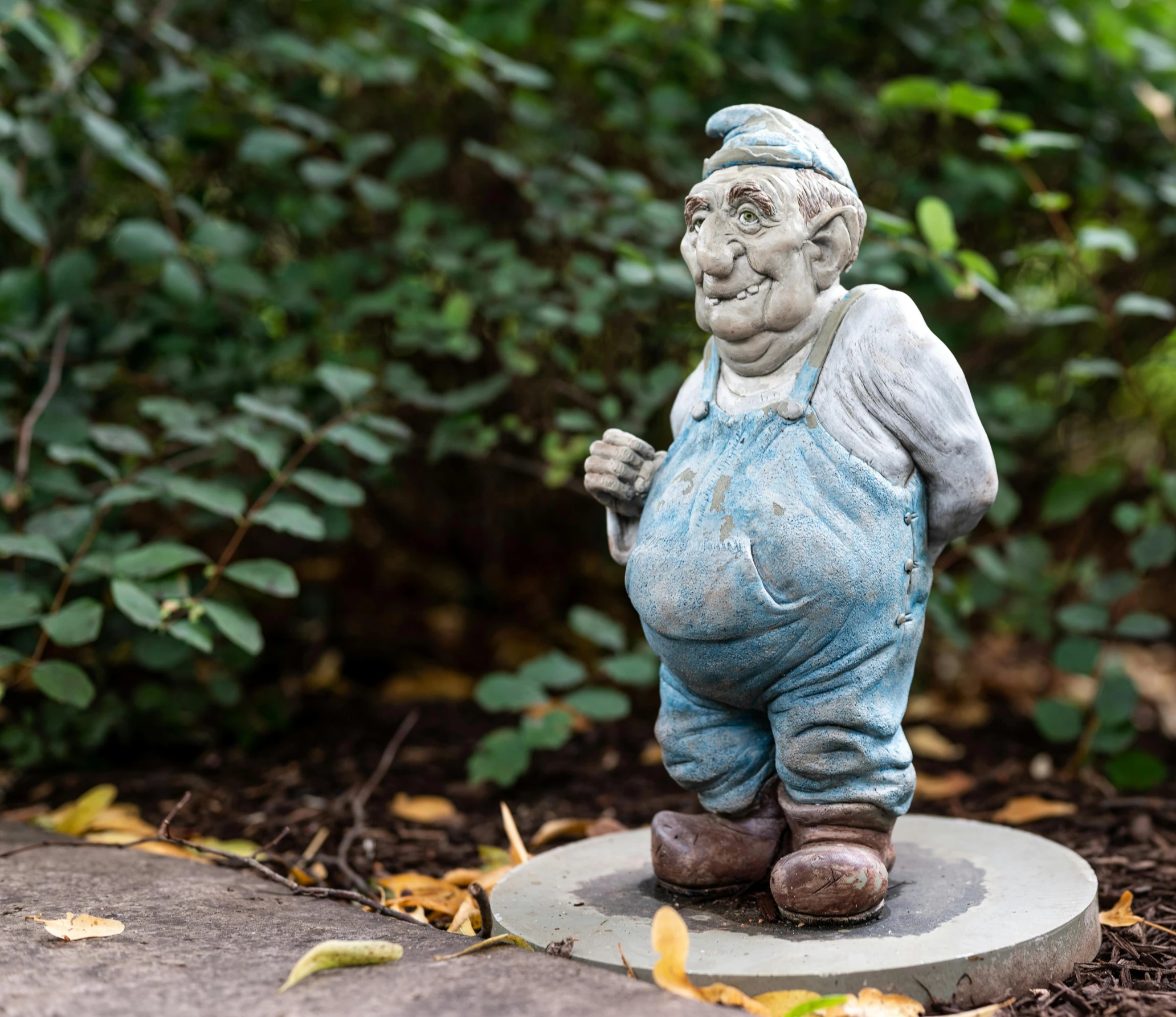 a statue of an old man in a garden, blue elf, giddy smirk, medium, on sidewalk