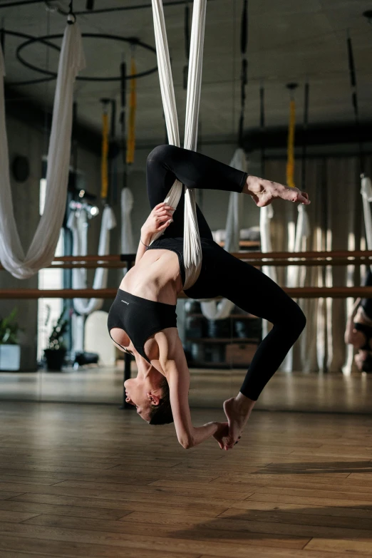 a woman doing a handstand on a hammock, by Matija Jama, arabesque, in a gym, thumbnail, flight, null