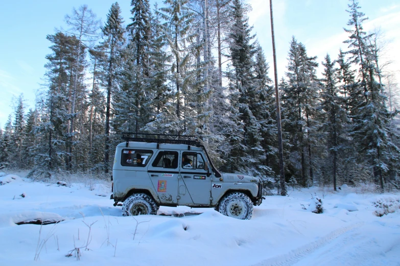 a jeep driving through a snow covered forest, by Veikko Törmänen, hurufiyya, bulky build, square, grey, 8k octan photo