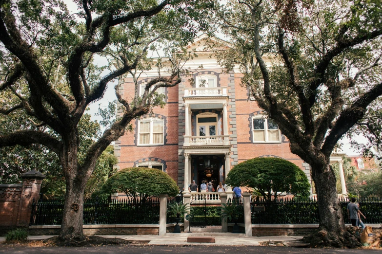 a couple of trees that are in front of a building, by Carey Morris, unsplash, in savannah, victorian manor, group photo, ignant