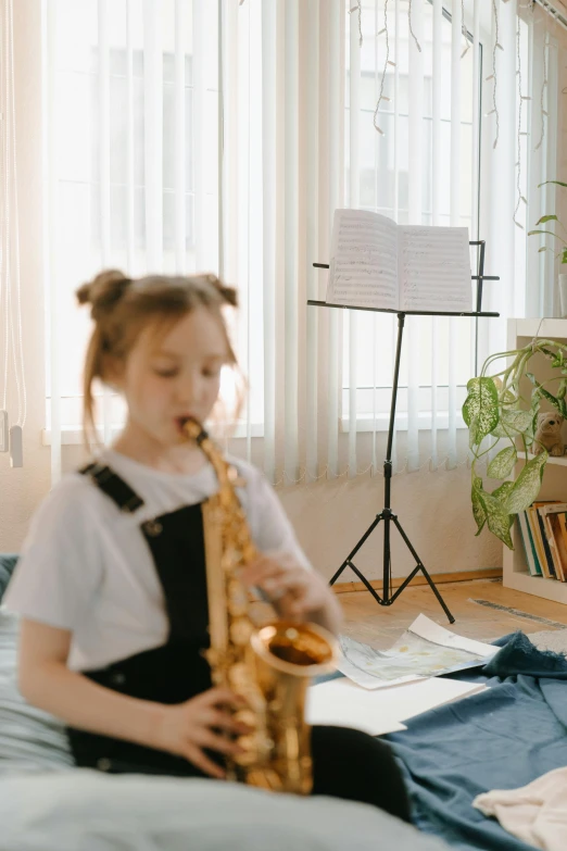 a little girl sitting on a bed playing a saxophone, pexels contest winner, studying in a brightly lit room, gif, very grainy image, 15081959 21121991 01012000 4k