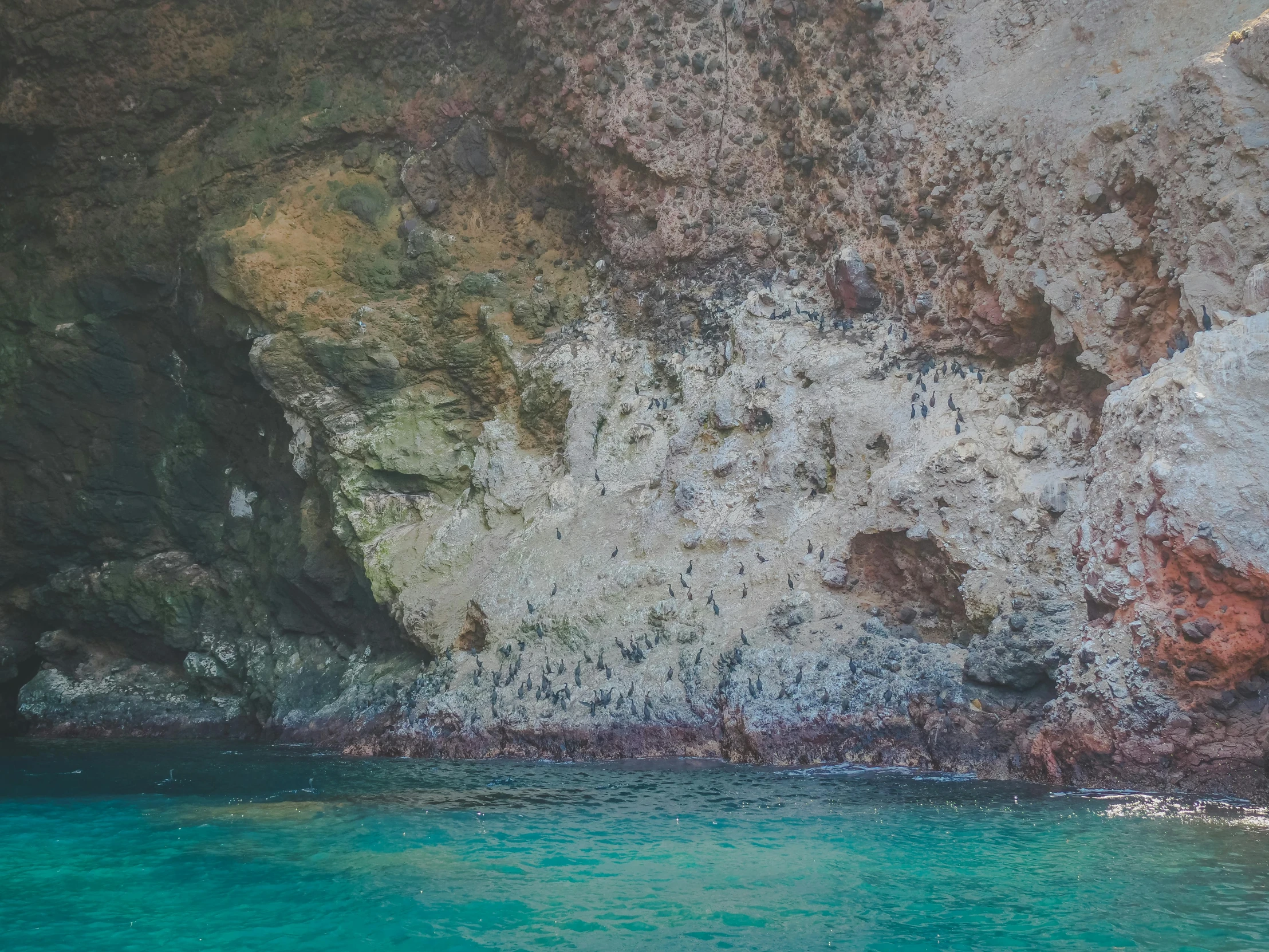 a man riding a surfboard on top of a body of water, a photo, by Elsa Bleda, unsplash, renaissance, natural cave wall, background image, maui, deep colours. ”