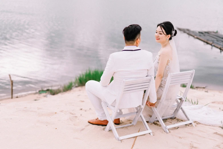 a man and a woman sitting next to each other on a beach, pexels contest winner, romanticism, wearing a white tuxedo, ao dai, sitting on a chair, youtube thumbnail