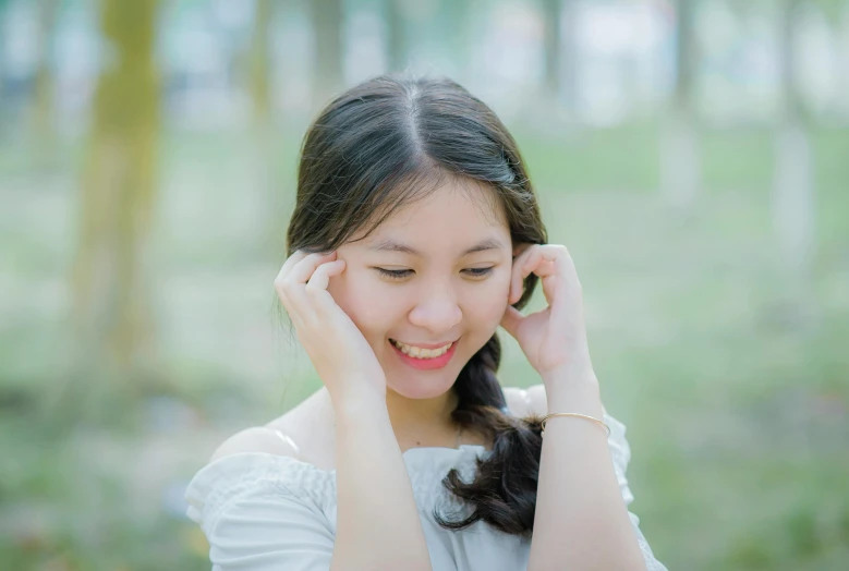 a woman in a white dress holding a cell phone to her ear, by Tan Ting-pho, pexels contest winner, realism, ( shy smiling face ), young asian girl, at a park, ruan cute vtuber
