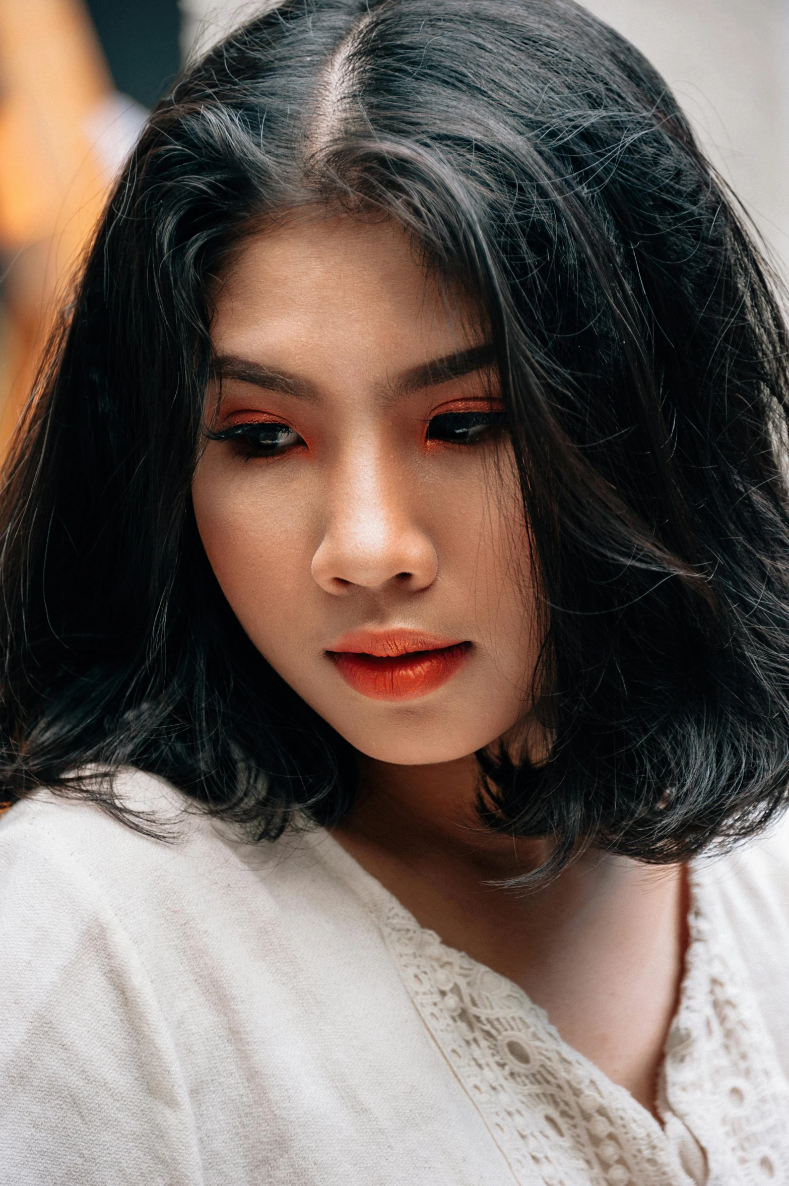 a woman with long black hair wearing a white shirt, trending on pexels, coral lipstick, malaysian, portrait mode photo, black and orange