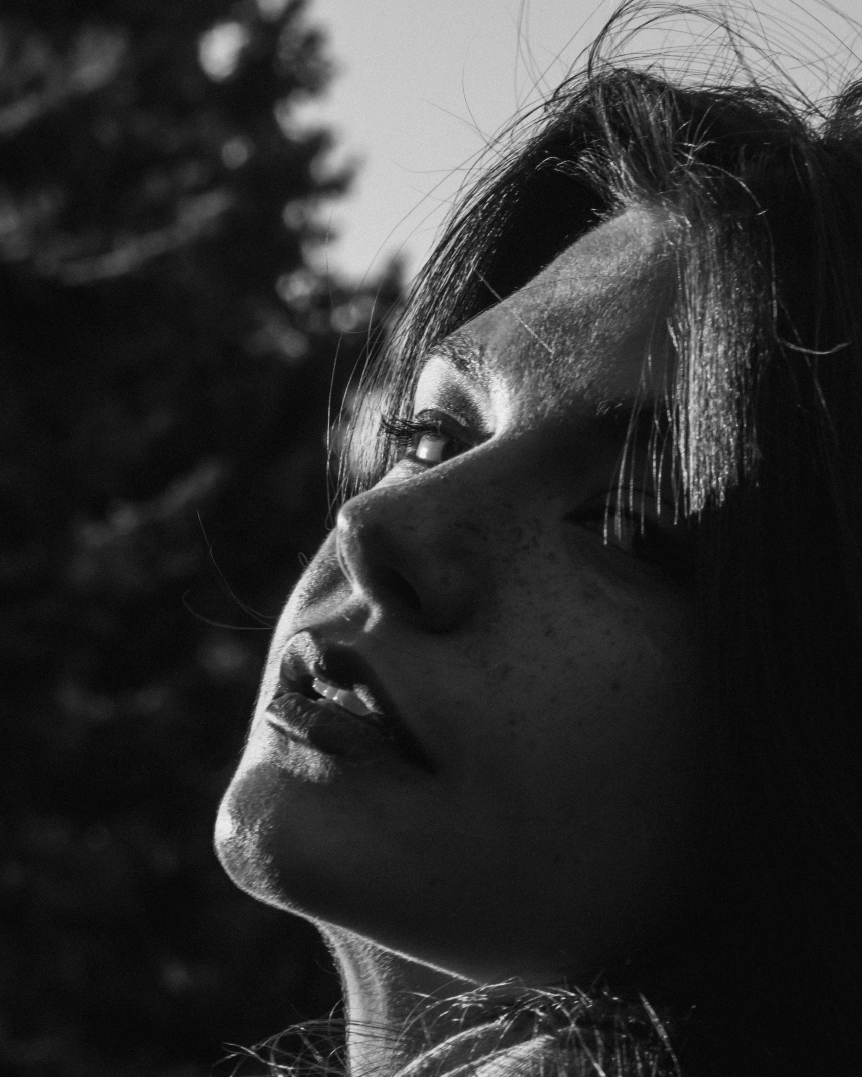 a black and white photo of a woman, by Adam Marczyński, unsplash, realism, sun glare, thoughtful ), noseless, looking up