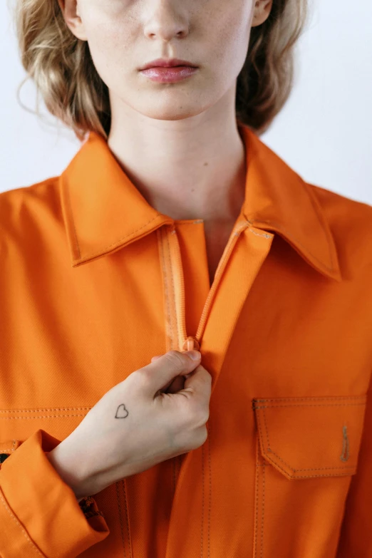 a close up of a person wearing an orange shirt, zippers, cropped wide sleeve, full product shot, technical suit