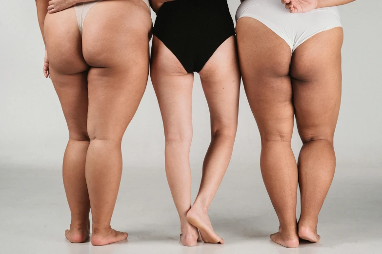 a group of women standing next to each other, by Matija Jama, trending on pexels, renaissance, round thighs, obese ), her skin is light brown, looking from behind