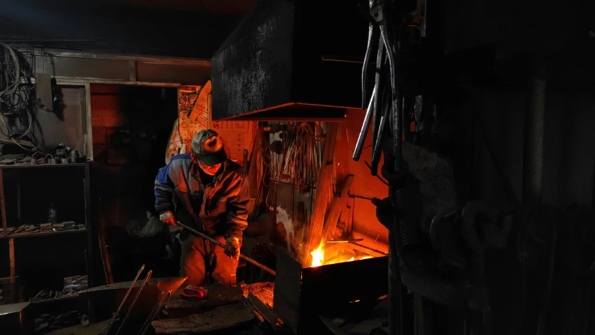 a man that is standing in front of a fire, inside iron and machines, cast iron material, profile image, pouring