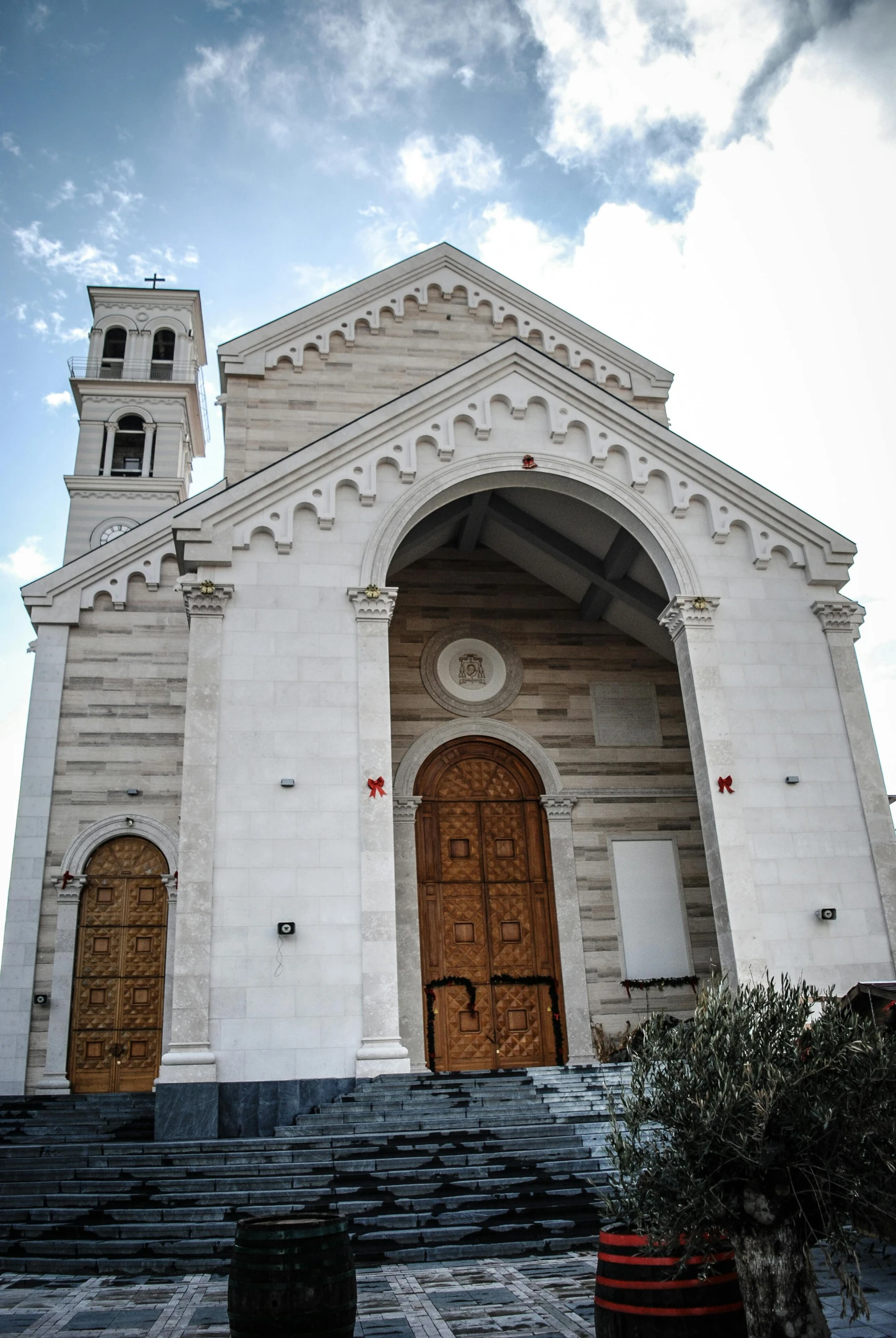 a large white church with a clock tower, by Carlo Carrà, entrance, yggrdasil, buttresses, guido reni style