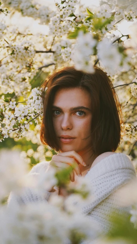 a woman standing in front of a flowering tree, inspired by Elsa Bleda, trending on unsplash, short brown hair and large eyes, portrait. 8 k high definition, anastasia ovchinnikova, detailed medium format photo