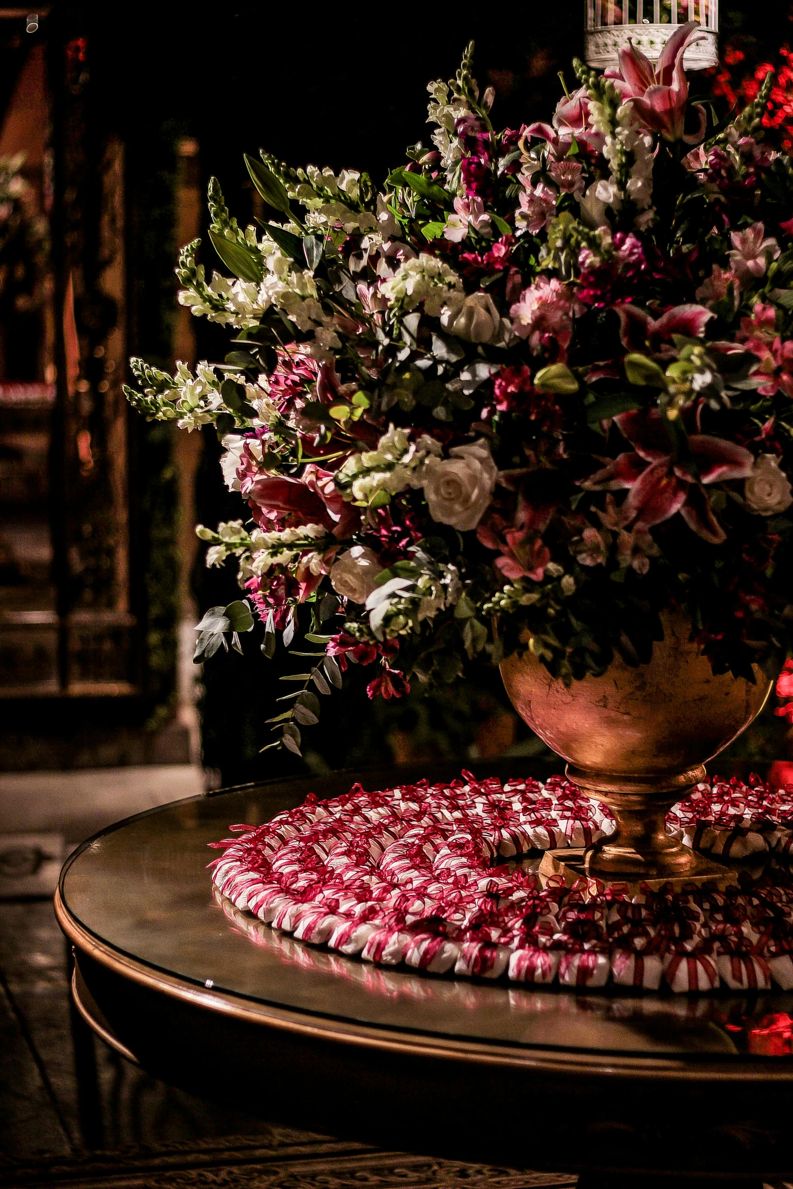 a vase of flowers sitting on top of a table, baroque, crimson themed, luxurious indoor setting, award winning, embroidered velvet