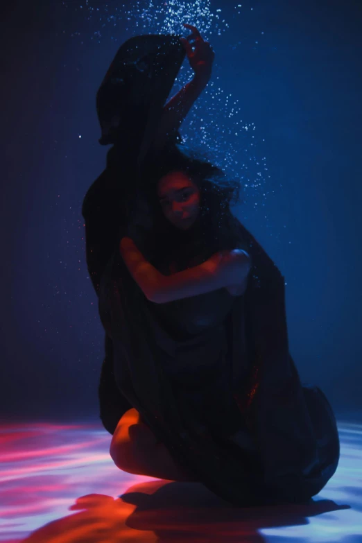 a woman sitting on the ground under water, unsplash, conceptual art, couple dancing, woman in black robes, ( ( theatrical ) ), lorde
