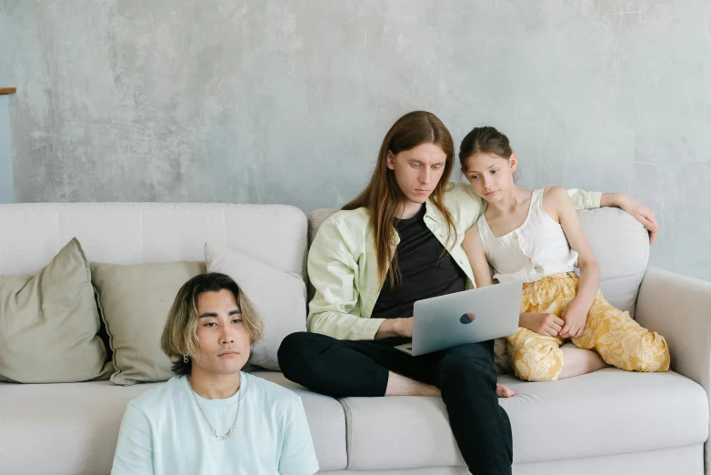 a couple of people sitting on a couch with a laptop, with a kid, dasha taran, looking serious, taejune kim