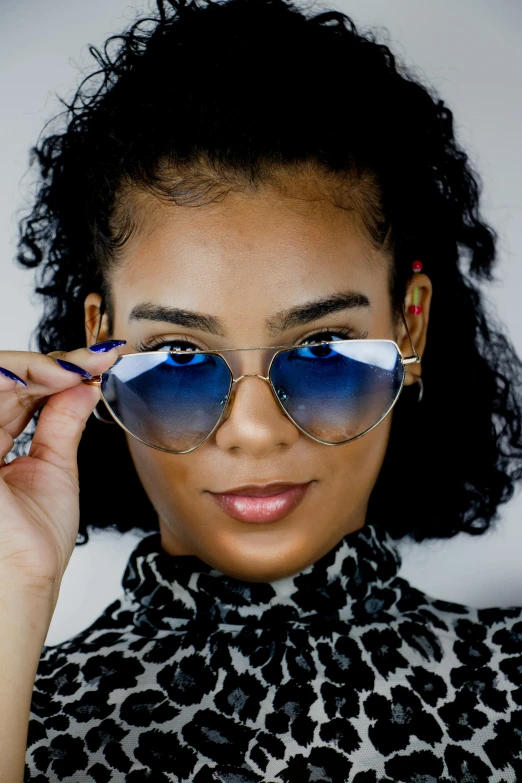 a close up of a person wearing sunglasses, wearing blue sunglasses, wearing gold glasses, mixed-race woman, curated collection