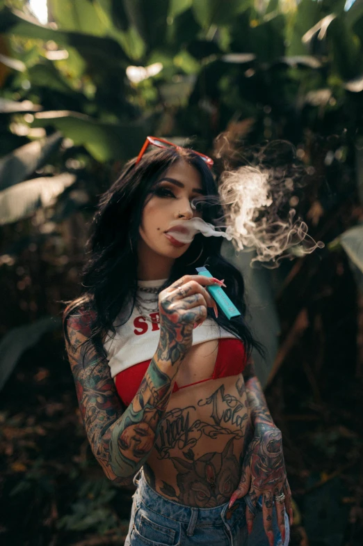 a woman with tattoos smoking a cigarette, inspired by Elsa Bleda, trending on pexels, in a jungle, rapper, witchcore, nug pic